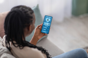 Young black lady checking her heart rate on mobile phone