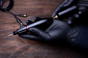 the hands of the permanent makeup artist in black sterile gloves, he tries to connect the wireless...