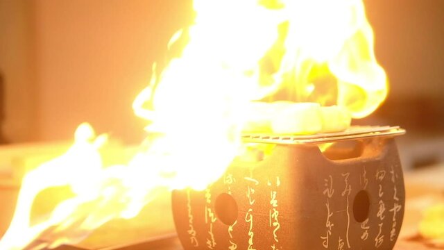 Chef burner scallop on with fire on stove for show customer in the restaurant.