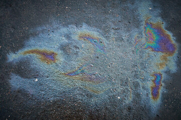 Colored spots of oil or gasoline on the asphalt as a texture or background.