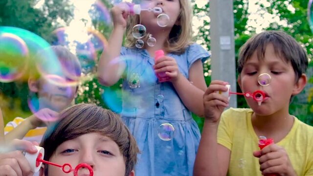 Children blow bubbles on the street. Selective focus.
