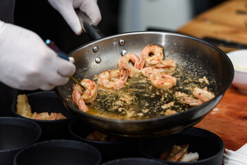 cooking process of Suquet de Peix soup with potatoes, herbs and fish with the addition of picada close-up in a saucepan on the table.