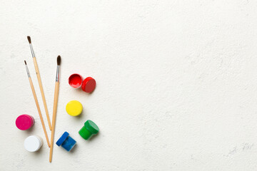 art palette with paint and brushes, close up. Top view with empty space. workplace for creativity. home teaching concept drawing