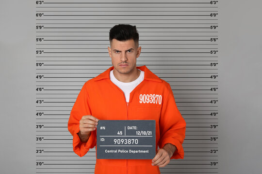 Prisoner with mugshot letter board at police department