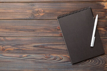 school notebook on a colored background, spiral black notepad on a table Top view