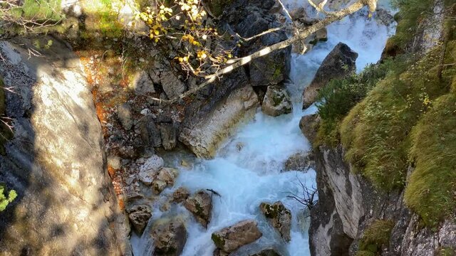 Small torrential river leads through rocky canyon on the Karwendelsteg hiking trail in the near of Scharnitz in Austria, tilt shot close up