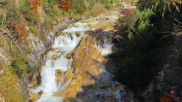 Amazing colorful landscape with waterfall on the Karwendelsteg trail in the near of Scharnitz in Austria with deciduous trees, tilt shot close up