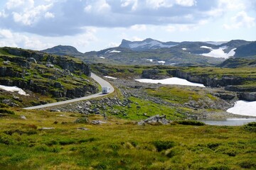 Fototapeta na wymiar National Tourist Route Aurlandsfjellet, Known locally as the Snow Road (Snøvegen). A white bus drives a winding road across the plateau. Norway
