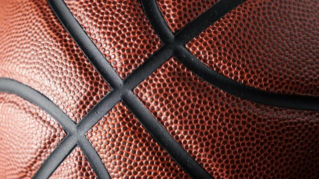 Close up shot of rotating basketball ball on dark black background. Basketball concept.
