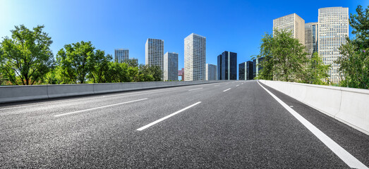 Empty asphalt road and city skyline with buildings in Beijing, China.