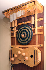 Door harp of a musician, musical instrument with various tuned sound devices such as strings, gong, metal and wooden tubes, which are struck randomly through the door movement and wind