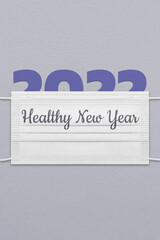 New Year's card with paper figures 2022 under a medical mask with an inscription Healthy New Year.
