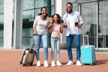 Happy black family traveling, holding documents, screaming yes