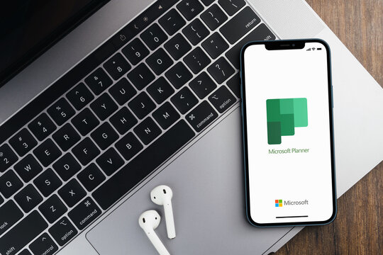 Microsoft Planner app on the smartphone screen on wooden background with a computer beside it. Rio de Janeiro, RJ, Brazil. December 2021