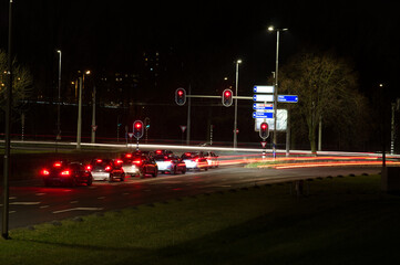 Intersection with a row cars at night with traffic lights and traffic blurred by motion in Arnhem in the Netherlands