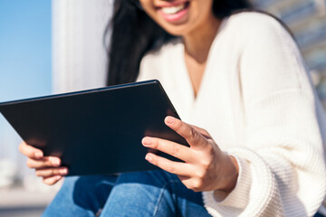 unrecognizable young woman using tablet outdoors