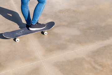 skateboard and feet on a concrete floor