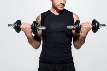 Plakat Cropped view of athletic sportsman training with dumbbells isolated on grey