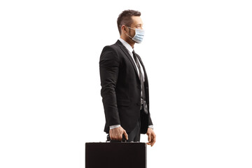 Businessman holding a briefcase and wearing a protective face mask