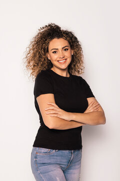 Smiling blonde woman with curly hair in studio