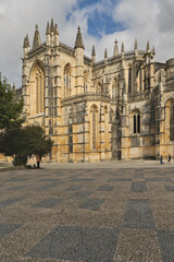 the western fa&ccedil;ade of the Batalha Monastery facing the large square with its equestrian statue of general Nuno &Aacute;lvares Pereira in Batalha, Portugal
