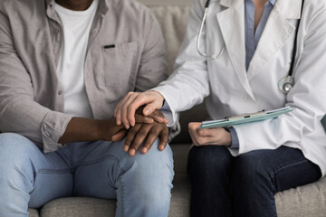 Disabled mature man receiving medical assistance from young caregiver at home