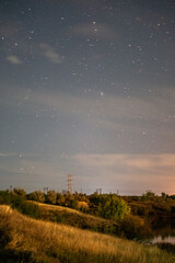 stars and mountains forest in the night . Night landscape. Nightsky and clouds . Stars in the sky . Lights of the city . 