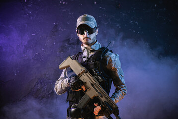 Fototapeta premium Futuristic soldier with a rifle on the black smoky background.