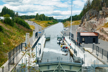 Fototapeta na wymiar Kouvola, Finland - 5 August 2021: Kimola Canal between lakes. Gateway is open for boats going though.