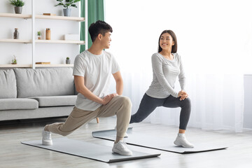 Fototapeta premium Happy asian couple exercising at home, copy space