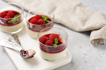 Italian dairy dessert panna cotta with raspberry jam, fresh raspberries and mint on marble board