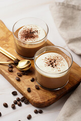 Italian chocolate and coffee mousse dessert semifreddo - half-frozen ice cream with whipped cream and cocoa powder in small glasses