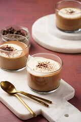 Italian chocolate and coffee mousse dessert semifreddo - half-frozen ice cream with whipped cream and cocoa powder in small glasses on purple surface
