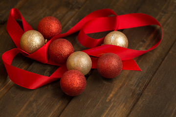 Christmas decorations red and gold shiny balls on a wooden background.