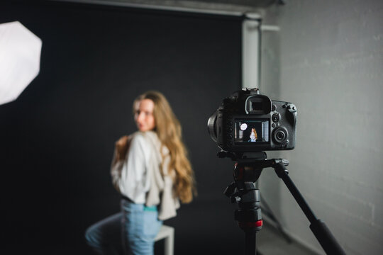 Female standing in front of photo camera in studio