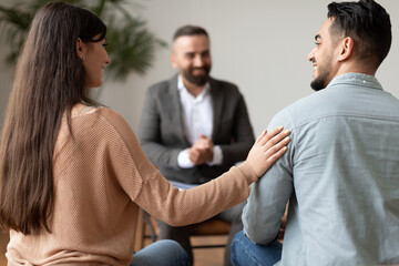 Happy couple reconciling at therapy session in therapists office