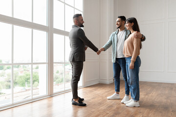 Couple Buying New Apartment, Shaking Hands With Realtor