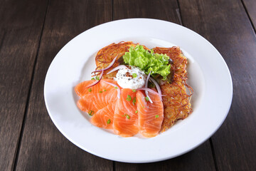 Potato pancakes with poached egg and red fish. Poached egg on potato pancakes. The concept of the restaurant menu. Top view with space to copy. Flat position.