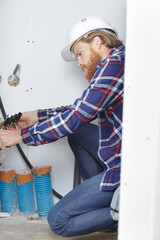 man during installation of pipes indoors