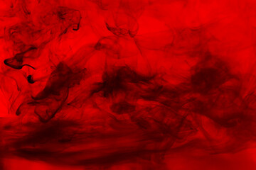 Black abstract smoke on a red background.