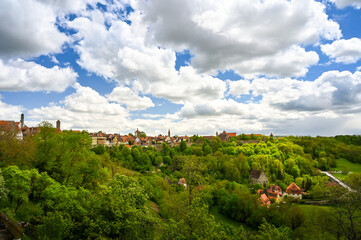 Fototapeta na wymiar Skyline of the old town of Rothenburg ob der Tauber, Germany at the horizon under a partly cloudy sky.