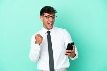 Business caucasian man isolated on blue background with phone in victory position