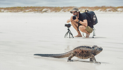 Galapagos islands wildlife photography photographer tourist man taking photos of marine iguana...