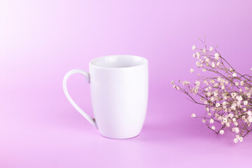 White cup and flower branch Gypsophila on pink background.  mock up minimal concept with copy space.