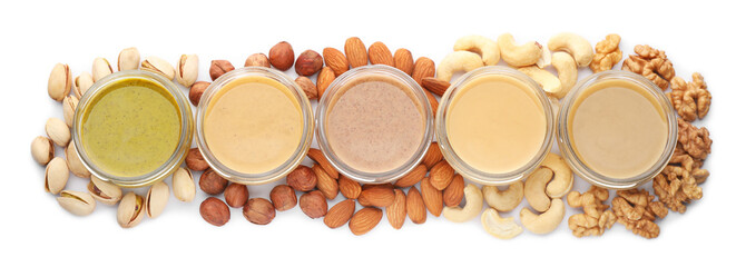 Jars with butter made of different nuts on white background, top view