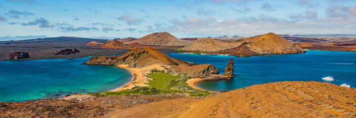 Galapagos islands travel banner. Bartolome Island, volcanic islet in the Islas Galapagos archipelago. Panoramic view of Sullivan bay, golden beach and Santiago island from hiking on cruise excursion. - obrazy, fototapety, plakaty