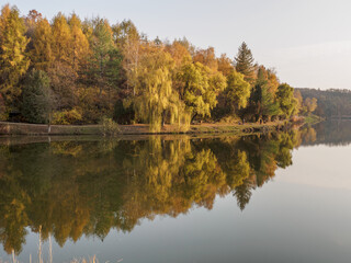 Reflection of autumn trees in the water of the Lake Malomv&ouml;lgy