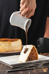 Fototapeta premium Sliced san sebastian cheesecake with coffee on wooden table