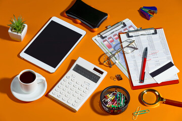 Business items in the office, laid out in a composition on a bright, colorful background. Top view.