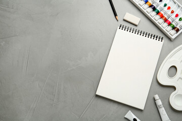 Flat lay composition with blank sketchbook on light grey stone table. Space for text
